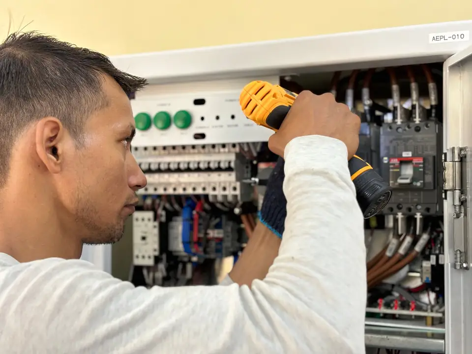 Stock view of a technician working at an electrical panel