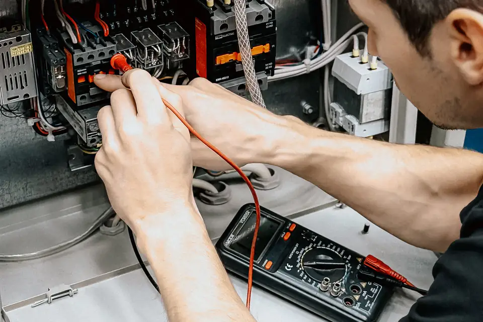 Electrician testing a panel with a multimeter